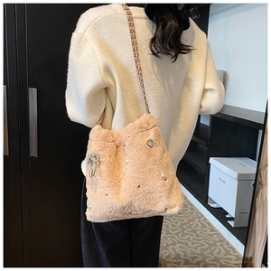 Vue détaillée du sac seau rose pelucheux avec perles, strass et bandoulière chaîne
