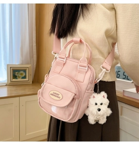 Pink mini canvas bag with cute dog pendant shown in a warm lifestyle interior