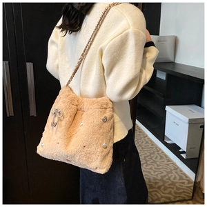 Détail du sac bandoulière en peluche marron clair avec perles et chaîne à nœud strass