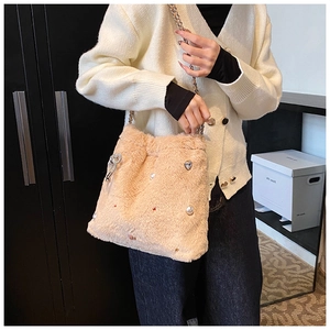 Détails du sac seau en peluche beige avec perles et breloques en forme de cœur