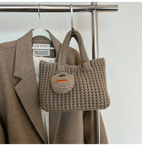 Detail of coffee brown chunky knit tote bag with handmade leather label and mini coin purse