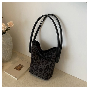 Detail of leopard print bucket bag featuring artistic dual long handle design and texture
