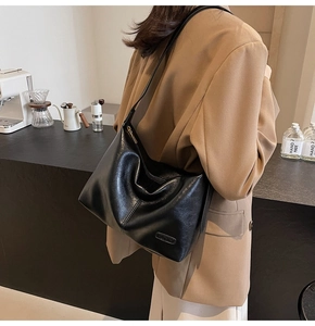 Détail de la texture d'un sac cabas en cuir noir avec fermeture éclair et bandoulière