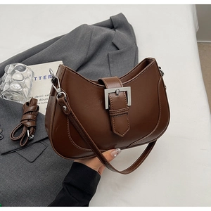 Detail of dark brown leather hobo bag with a silver square buckle and double straps