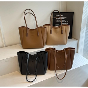 Close-up of four stylish leather tote bags in caramel, beige, black and brown colors
