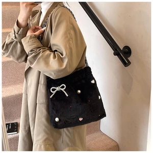 Détail du sac à bandoulière en peluche avec nœud en strass, perles et chaîne en métal