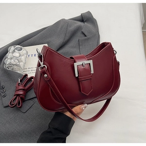 Detail of burgundy crescent shoulder bag with silver buckle and detachable strap