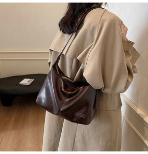 Vue de profil d'une femme portant un grand sac cabas vintage en cuir marron foncé