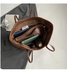 Interior view showing large capacity and striped lining of this brown leather tote bag