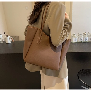 Detailed view of brown litchi pattern leather tote bag shown on a female model