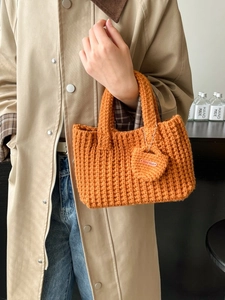 Chic orange chunky knit bucket handbag with handmade tag for autumn winter styling