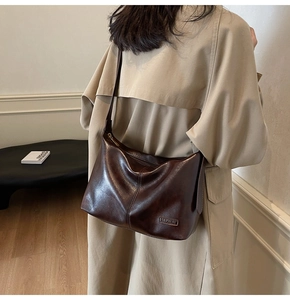Détail du grand sac cabas marron foncé montrant la texture cirée et la bandoulière