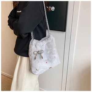 Détail du sac seau en fausse fourrure grise avec nœud en strass et perles sur chaîne