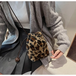 Detailed close-up of leopard print plush bucket bag with brown drawstring and decorative knot