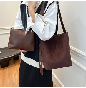 Detail of dark brown faux suede bucket bag and matching leather pouch for women