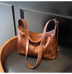 Détails du grand sac bourse en cuir marron vintage avec finition cirée et logo métal