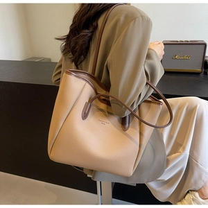 Detail of a large apricot leather tote bag with contrasting brown handles and side view