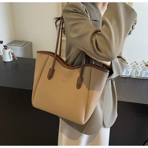 Close-up of khaki pebbled leather tote bag with brown trim and Fashion trend Studio text