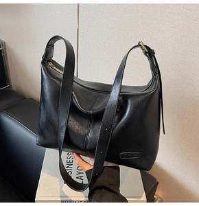 Gros plan du sac cabas en cuir noir vintage avec zip doré et logo carré sur des livres