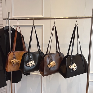 Détail de sacs cabas rétro en marron, noir et beige avec pendentifs léopard chic