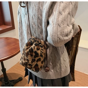 Detail of leopard print faux fur bucket bag with drawstring closure and slim shoulder strap