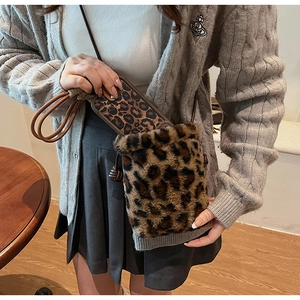 Detail showing plush leopard print bucket bag with matching phone case accessory