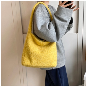 Detail van gele pluche shopper met zachte mohair textuur en hobo-stijl schouderband op de tas