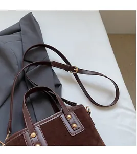 Détails du sac seau patchwork marron foncé avec texture daim et rivets dorés mats