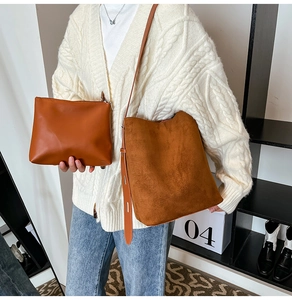 Close-up of caramel suede crossbody bucket bag and matching leather pouch set for women
