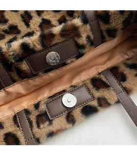 Detail of leopard print plush tote bag featuring faux leather trim and silver magnetic clasp
