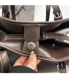 Détail du sac cabas en cuir marron avec fermeture magnétique et coutures solides