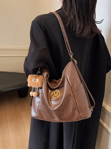 Vintage dark brown large capacity shoulder bag with gold M logo and plush pendant