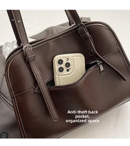 Détail de la poche antivol arrière sur un cabas vintage marron avec téléphone pour la taille