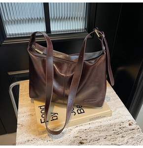 Détail du sac cabas marron foncé vintage avec texture cuir huilé sur marbre chic
