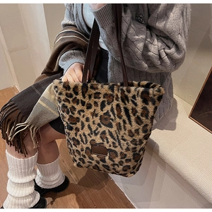 Detail of leopard print plush tote bag featuring soft faux fur and brown leather straps
