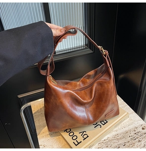 Vue détaillée du cuir marron lisse et du logo embossé sur le grand sac cabas vintage