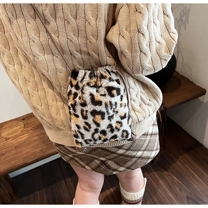 Detailed close-up of leopard print faux fur bucket bag with brown drawstring strap