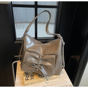 Detail of taupe synthetic leather shoulder bag with oversized bow and knot decor