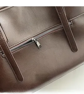 Détail d'une fermeture éclair en métal sur un cabas en cuir vintage marron foncé
