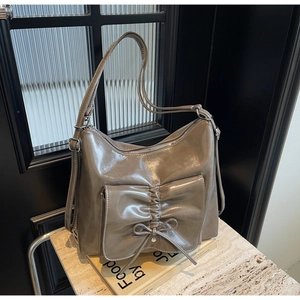 Detail of mocha brown PU leather tote bag with pleats and decorative bow accessory