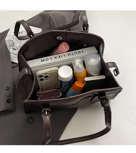 Vue de dessus de l'intérieur spacieux d'un sac cabas vintage marron avec des accessoires