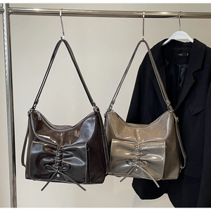 Detail of coffee and taupe hobo bags with decorative bows and white contrast stitching