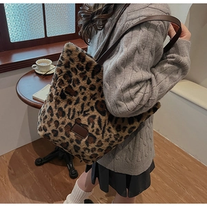 Dettaglio a spalla di una borsa tote grande in peluche leopardato con manici in pelle