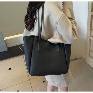 Detail of black lychee grain leather tote bag with elegant embossed logo lettering