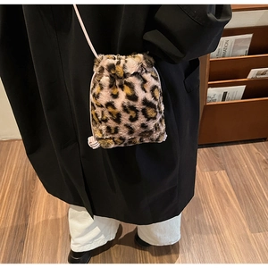 Detail of leopard print faux fur bucket bag with pink drawstring and slim shoulder strap