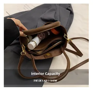 Detailed interior of brown litchi grain leather bucket bag showing compartments and capacity