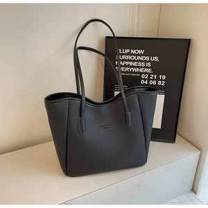 Close-up of black leather tote bag with lychee texture and Seokku brand lettering