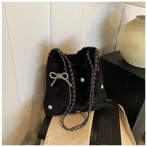 Détail du sac seau en fausse fourrure noire avec un nœud étincelant en strass argentés