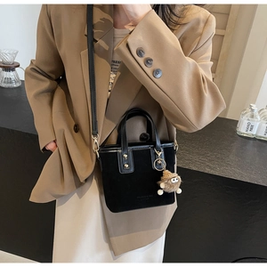 Détail du mini sac seau noir avec texture en daim et finitions dorées élégantes