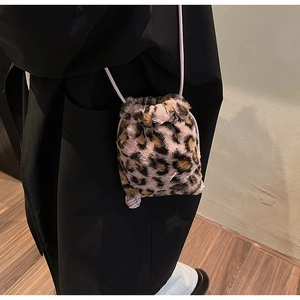 Detail view of leopard print plush bucket bag with drawstring closure and soft faux fur texture
